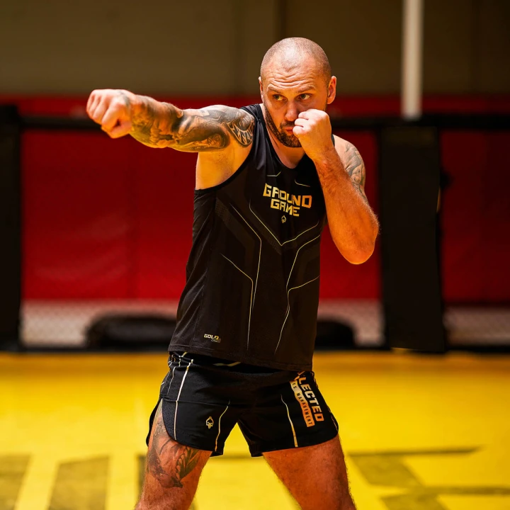 Trening sportów walki w tank topie Ground Game Gold 2.0 na macie MMA