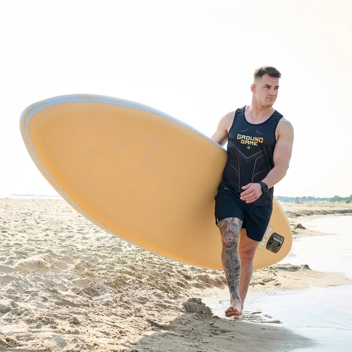 Letnia stylizacja sportowa z tank topem Ground Game Gold 2.0 i deską surfingową