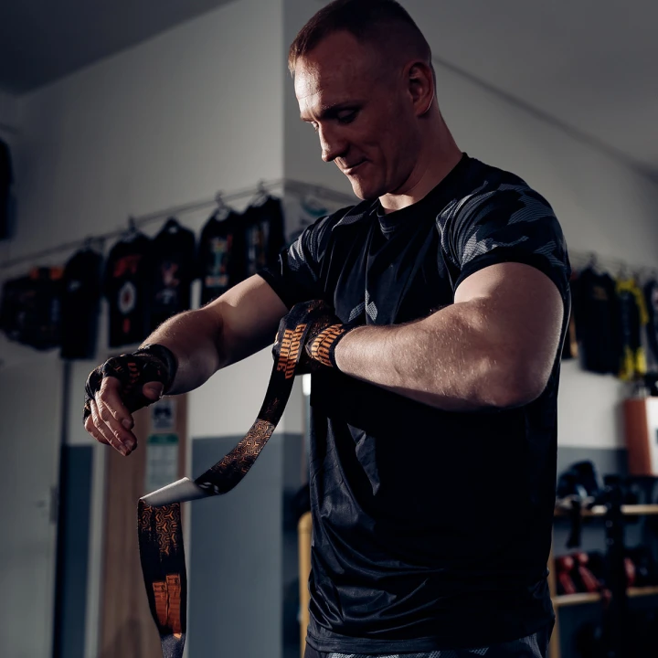 Zawodnik wiążący bandaże bokserskie 4m Ground Game Samurai przed treningiem
